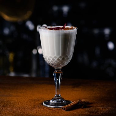 Barın arka planında dekore edilmiş bir bardak eggnog kokteyli, bar arka planında beyaz kokteyl.