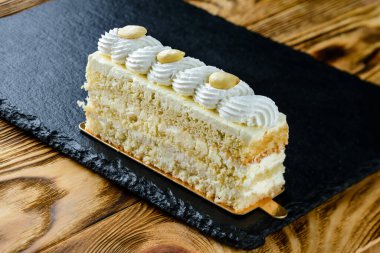 Katmanlı kremalı pasta, ahşap bir masanın üzerindeki pasta katmanları.