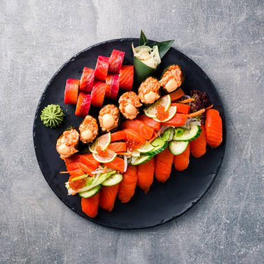 Farklı suşi çeşitleri. Japon yemek takımı farklı suşi ruloları tabağın üstünde, düz yatıyordu.