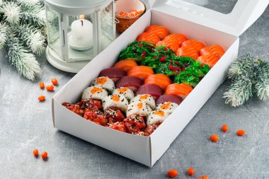 Restoranda Noel 'i ya da yeni yılı kutlamak, şenlikli akşam yemeği, suşi, Japon mutfağı, Asya' nın yeni yıl kutlaması için yemek teslimatı, Çin 'in yeni yılı için kutuda suşi.