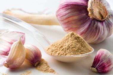 Beyaz masadaki sarımsak tozu kaşıkla, kuru sarımsak tozu. Sarımsak / Lahsun tozu toprakta, kurutulmuş sarımsak