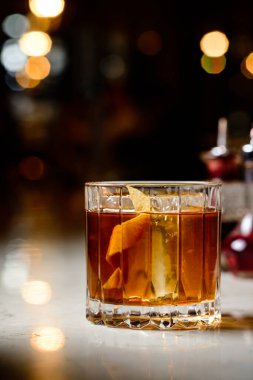 Tezgah bar arka planında eski moda Negroni klasik kokteyli. Viski Old Fashioned portakal aromalı buzlu servis edilir.