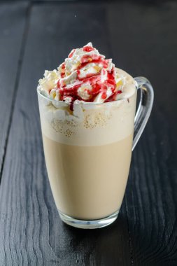 Buzlu kahve, çırpılmış süt ve karamelli dondurma büyük bardaklarda, ahşap masada.