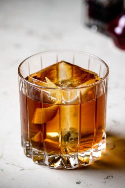 Tezgah bar arka planında eski moda Negroni klasik kokteyli. Viski Old Fashioned portakal aromalı buzlu servis edilir.