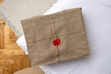 Keten iple bağlanmış bir kutu ve masada bir mürekkep mührü var. Keten kumaşla mühürlenmiş bir paket.