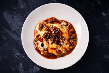 Fındıklı tatlı, karamel ve koyu arkaplanda fırınlanmış elma. Sonbahar yemeği teması. Üst görünüm, düz uzanma