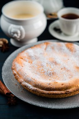 Süzme peynirli turta ve ahşap zemin üzerindeki krema şekeri, süzme peynirli tart ya da süzme peynirli tatlı peynirli cheesecake.