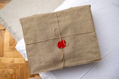 Keten iple bağlanmış bir kutu ve masada bir mürekkep mührü var. Keten kumaşla mühürlenmiş bir paket.