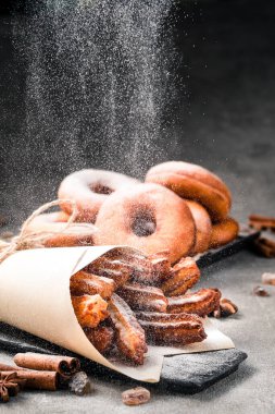 Geleneksel churros çubukları üzerine tarçın serpiştirilmiş şeker tozu, hamur tatlısı İspanyol tatlısı ve donut.