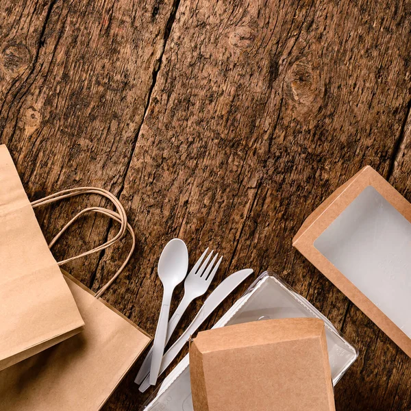 环保工艺纸制餐具 快餐盒 运送食物的盒子 回收的概念 零浪费 木制背景的环保食品派递箱 并附有复制空间 — 图库照片
