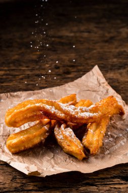 Geleneksel İspanyol tatlısı, şeker ve tarçınlı, yakın plan churros çubukları kağıt torbada taze sıcak.