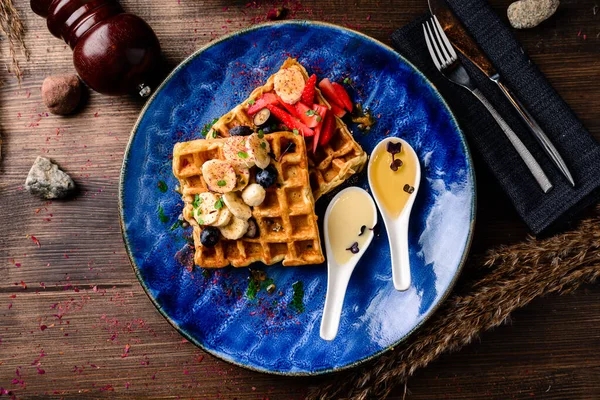 Traditional Belgian waffles with blueberries, banana and honey. Gourmet Breakfast. Viennese waffles with fresh fruit and berries and honey