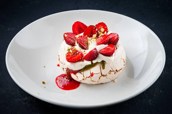 Homemade meringue dessert Pavlova cake with fresh strawberries. Summer dessert. French cake. Confectionery. Classic dessert. Strawberry dessert meringue