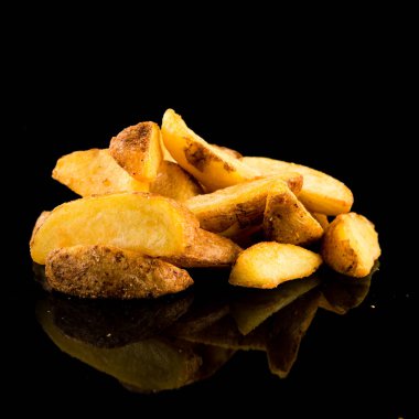 Siyah arka planda patates parçaları. Siyah arka planda izole edilmiş patates dilimleri.