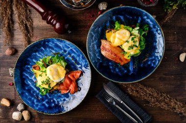 Ekmek üstü haşlanmış yumurta, füme domuz pastırması ve salata. Haşlanmış yumurta, bitki ve pastırmalı sandviç. Yumurtalı Benedict kahvaltısı. Yakın plan. Yumurtalı tost.
