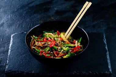 Sebzeli pirinç eriştesi koyu arka planda kızarır. Asya Pad Thai vejetaryen sebzeleri udon eriştesi. Asya usulü vejetaryen yemeği. Japon yemeği Soba eriştesi.