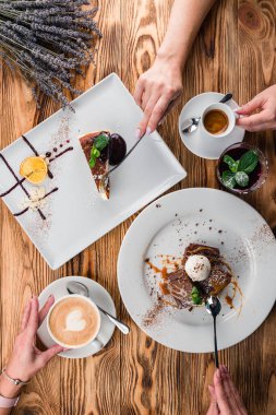 Kahvaltı konsepti: Kadın ellerine yakın olan kadınlar kahvelerini tatlı manzaralı içerler ellerini kapat, kahvaltı için düz bir masa hazırla.