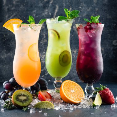 Portakal, nane, kivi ve yabanmersinli üç tropikal limonata kokteyli limonata ferahlatıcı limonata. Soğuk yaz içeceği ve kokteyl. Sağlıklı içecekler
