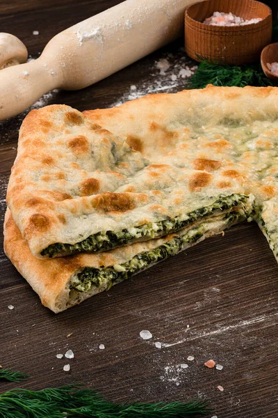 Traditional french quiche pie with spinach and cheese on wooden background. sliced spinach pie