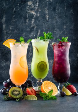 Portakal, nane, kivi ve yabanmersinli üç tropikal limonata kokteyli limonata ferahlatıcı limonata. Soğuk yaz içeceği ve kokteyl. Sağlıklı içecekler