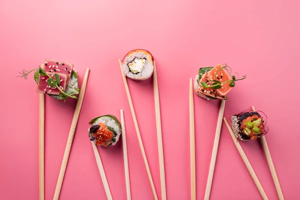 寿司盘中设置粉红色背景 情人节食物的概念 文字空间 平铺寿司卷与筷子粉红简约的背景 — 图库照片