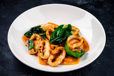 Sağlıklı Akdeniz yemeği için domates soslu kalamar halkaları, mürekkep balığı halkaları. Sebzeli deniz ürünleri güveci. Kalamar, İtalyan yemek pişirme kavramını ortaya çıkarır.