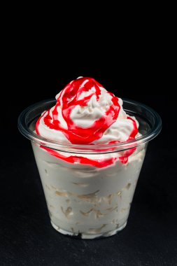 Plastik bardakta çilekli vanilyalı dondurma, plastik bardakta servis edilen vanilyalı dondurma izole edilmiş fotokopi alanı.