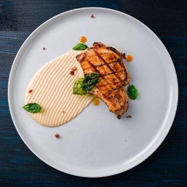 Baharatlı biftek, ızgara biftek, fırında patates ve sebze salatası. Izgara domuz pirzolası. Üst tarafta servis ediliyor.