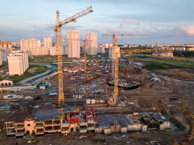 Vinçleri olan bir inşaat alanı. İnşaat işçileri inşa ediyor. Turnalı konut binalarının inşaat alanının havadan görüntüsü