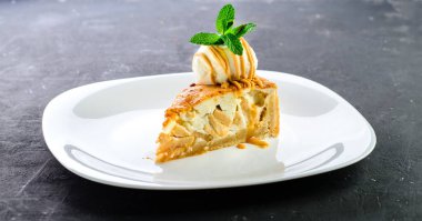 Vanilyalı dondurma ve karamel soslu lezzetli bir dilim elmalı turta. Bir dilim geleneksel Amerikan elmalı turtası ve dondurma, tatlı tatlı tatlı