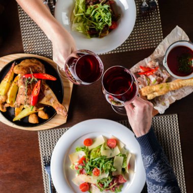 Romantik bir akşam yemeği ya da bir gurme restoranında kırmızı şarap kadehleriyle öğle yemeği için bir çift. Üst manzara, düz uzanma