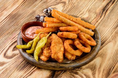 Atıştırmalık tabaklar, peynir çubukları, tavuk nugget, soğan halkaları, abur cubur ve sos karışımı. Bira tahtası bar menüsü, atıştırmalık seti.