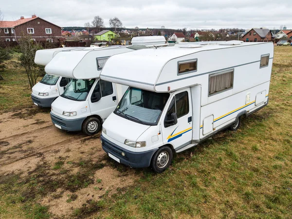 Mobil evlerin havadan çekilmiş fotoğrafı, otoparktaki üç karavan evi, karavan kampı. Eski tarz minibüsleri olan bir karavan.