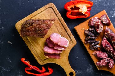 Sebzeli ızgara sosisler eski bir masanın üzerinde. Geleneksel yöntemlerle üretilen organik tarım ürünleri. Tütsülenmiş sosis.