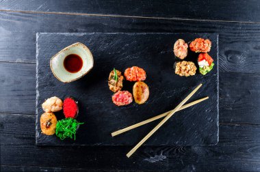 Farklı türde balıklı Gunkan Maki Sushi seti (somon, deniz tarağı, levrek, yılan balığı, karides) ve siyah arka planda havyar. Suşi menüsü. Japon yemek suşisi silah seti.