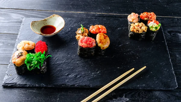 Set of Gunkan Maki Sushi with different types of fish (salmon, scallop, perch, eel, shrimp) and caviar on black background. Sushi menu. Japanese food sushi set gunkans.