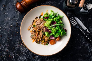 Izgara biftek ve taze sebze salatası, taze salatalı domuz bifteği, sulu barbekü yemeği.