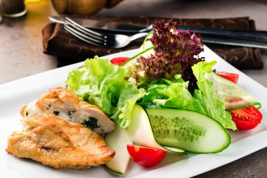 Pirzola Cordon Bleu, yanında da salata. Tavuk cordon bleu şnitzel, jambon ve peynire sarılmış et, ekmek ve kızarmış