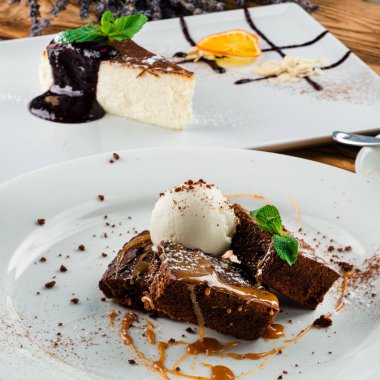 Çikolata soslu cevizli brownie, beyaz tabakta servis edilen vanilyalı brownie.