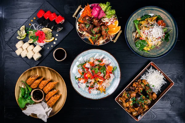 Asiatisk matlagning. Wok, nudlar och grönsakssallad och ätpinnar på mörk rustik bakgrund — Stockfoto