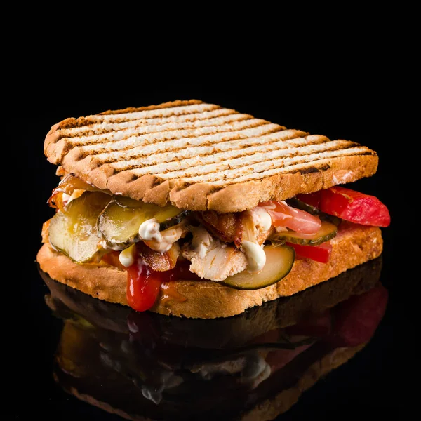 Курячий та солоний бутерброд на чорному склі — стокове фото