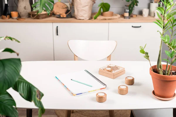 Blank öppnad anteckningsbok med kopp kaffe och memo not på bordet. arbetsplats med mugg kaffe, plat i kruka Snygg inredning i hemmakontor — Stockfoto