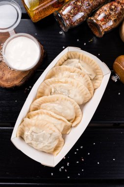 Hamur köftelerini bir kutuya doldurup, hamur köftelerini, Vareniki 'yi kağıt tabağa koyup teslim etmek için. Sokak yemekleri konsepti.