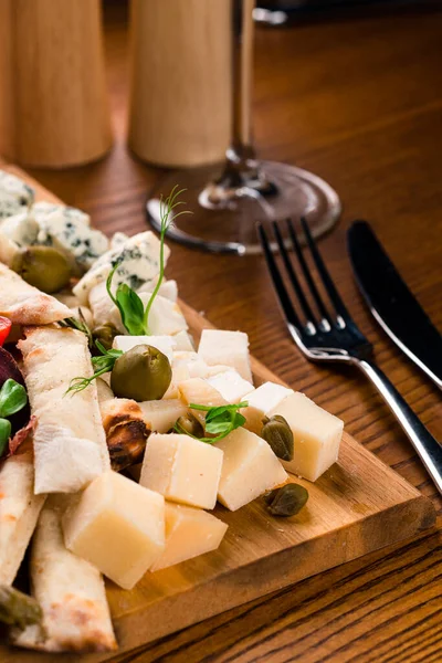 Cheese Board served with grapes, nuts on a wooden background — Stock Photo, Image