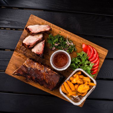 Mangalda ızgara pirzola, mangalda pirzola, patates kızartması ve sos, ahşap masa manzarası, düz yatış.