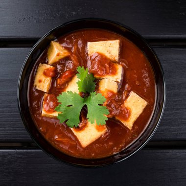 Kıtır ekmekli Hint domates çorbası. Kremalı domates çorbası, kızarmış ekmek ve siyah ahşap kaplamalı kişniş. Metin üstü görünümü için boşluk kopyala, düz yatay