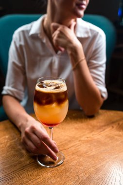 Masada kokteyl, soğuk kahve ve aperol kokteyli olan bir kadın restoranda aperol kokteyli içen bir kadın.