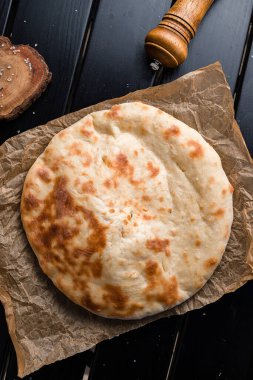 Geleneksel Gürcü ekmeği. Peynirle doldurulmuş Khychiny Geleneksel Kafkas ekmeği. Üst görünüm, düz uzanma