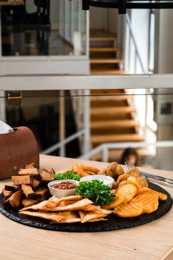 Bira atıştırmalıkları, kombo atıştırmalıkları bira aperatifleri, kızarmış ekmekler. Deef Fried Chicken Nuggets, Cheese Fingers, soğan halkaları ahşap masada tempura.