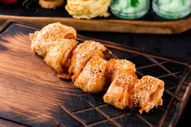 Tahta bir tahtanın üzerinde puf böreğinden yapılmış pizza calzone, ahşap bir masanın üzerinde katlanmış pizza Calzone.